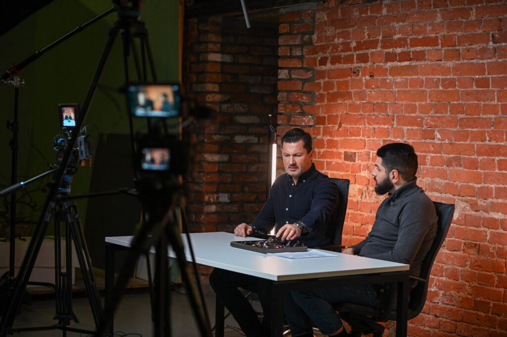 Interviu filmavimas prie plytų sienos