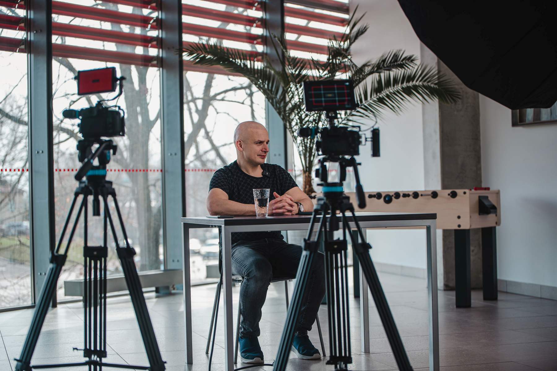 Vyras duoda interviu prieš kamerą biure