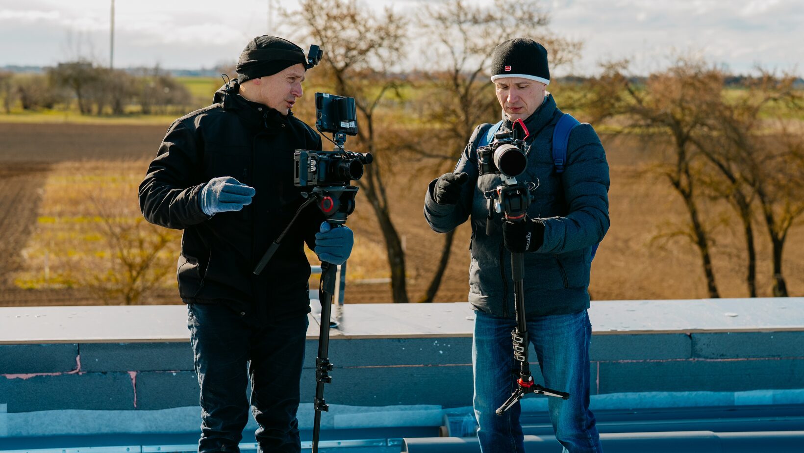 Du videografai su kameromis filmuoja lauke