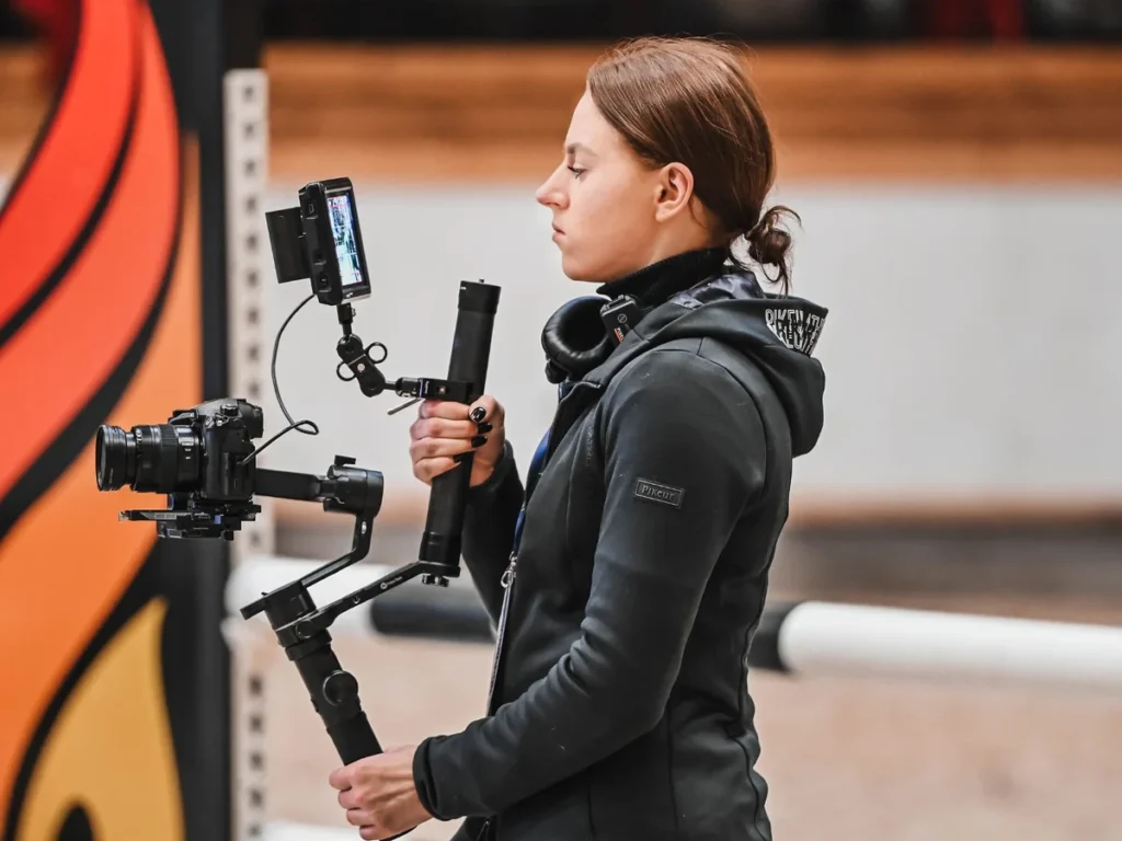 Mačiukas Media camera operator filming a show-jumping event with a gimbal