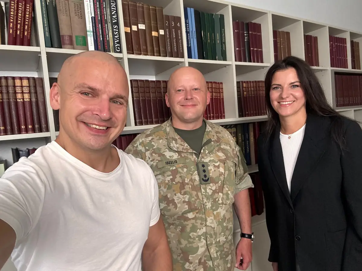Eugenijus Mačiukas, plk. Linas Idzelis ir Eglė Pilypaitė prie knygų lentynos filmavimo dieną