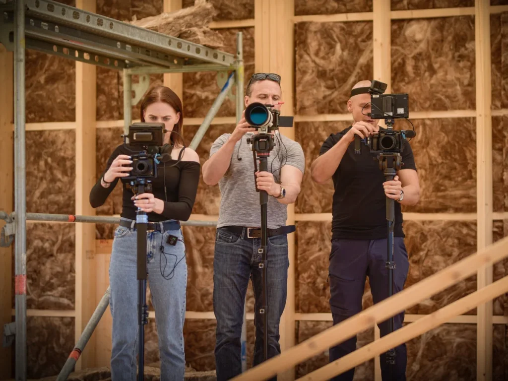 Three Mačiukas Media camera operators filming on a construction site